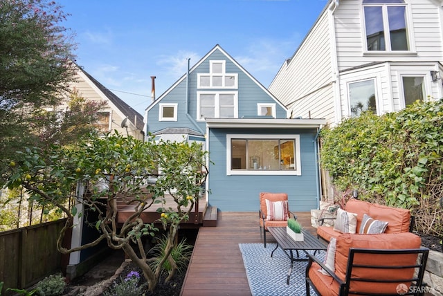 back of property featuring an outdoor living space, a deck, and fence