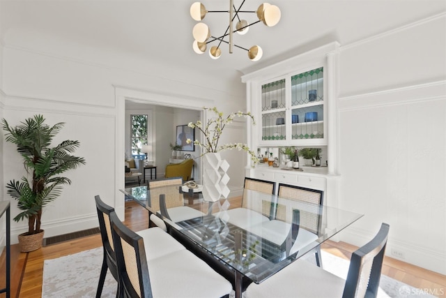 dining area featuring light wood finished floors and a notable chandelier