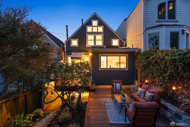 rear view of house with an outdoor living space, a wooden deck, and fence