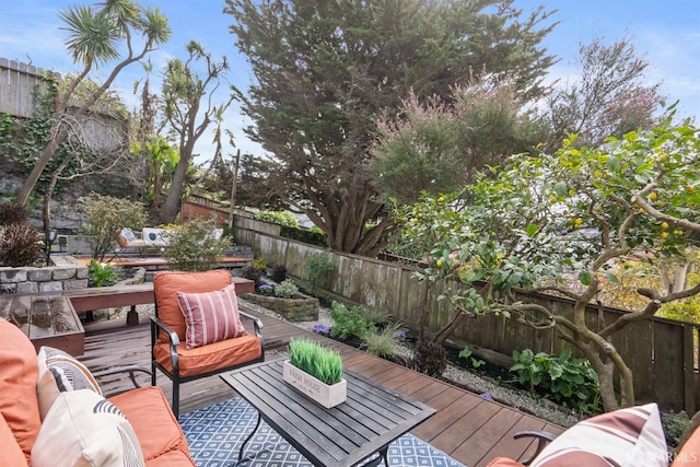 wooden terrace featuring an outdoor hangout area and a fenced backyard