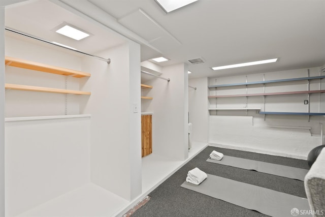 walk in closet with visible vents and carpet