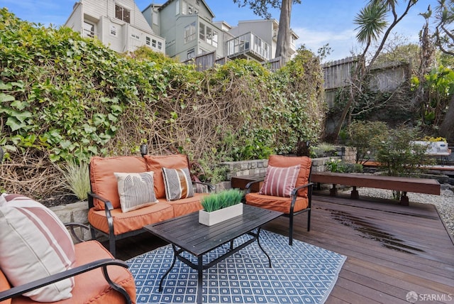 wooden deck with an outdoor living space and fence