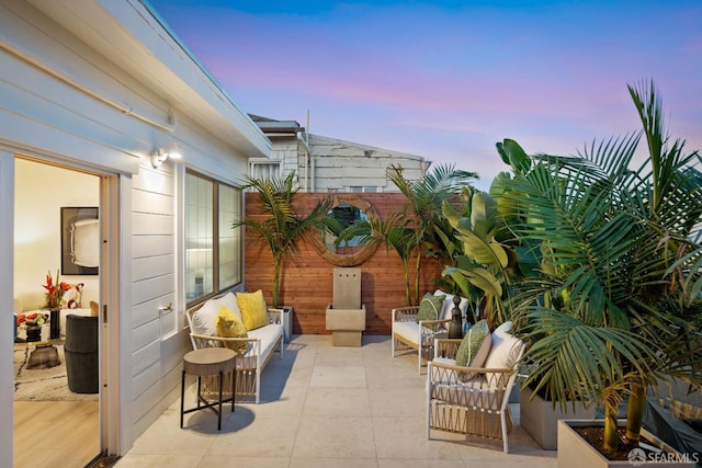 patio terrace at dusk featuring an outdoor living space