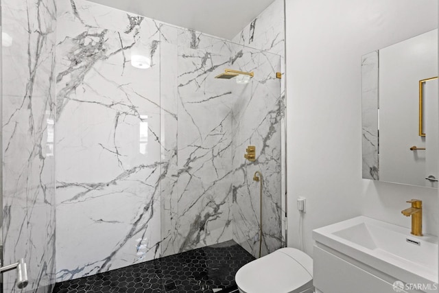 full bathroom with a marble finish shower, toilet, and vanity