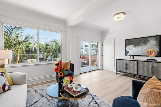 living area featuring beamed ceiling, wood finished floors, and ornamental molding