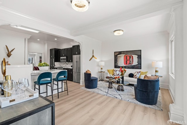 living area with recessed lighting, baseboards, light wood-type flooring, and ornamental molding