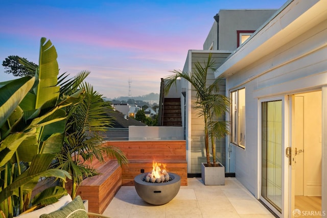 patio terrace at dusk featuring a fire pit