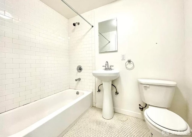 bathroom featuring tiled shower / bath combo, tile patterned floors, and toilet