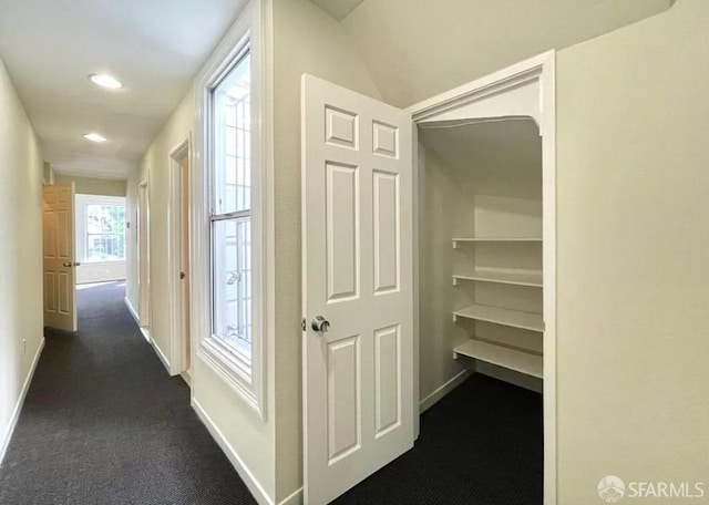 hallway with dark colored carpet