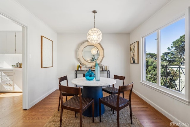 dining room featuring light wood-style flooring and baseboards