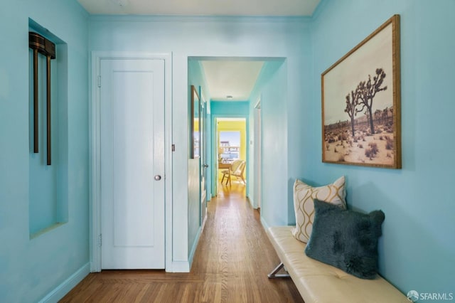 hallway featuring wood finished floors and baseboards