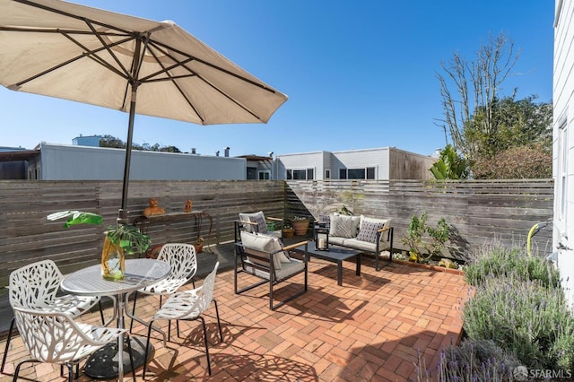 view of patio featuring outdoor dining space, a fenced backyard, and an outdoor hangout area