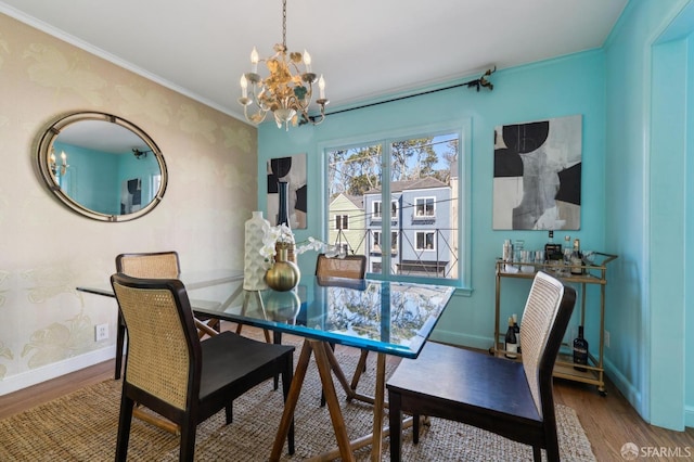 dining room featuring a chandelier, crown molding, wood finished floors, and baseboards