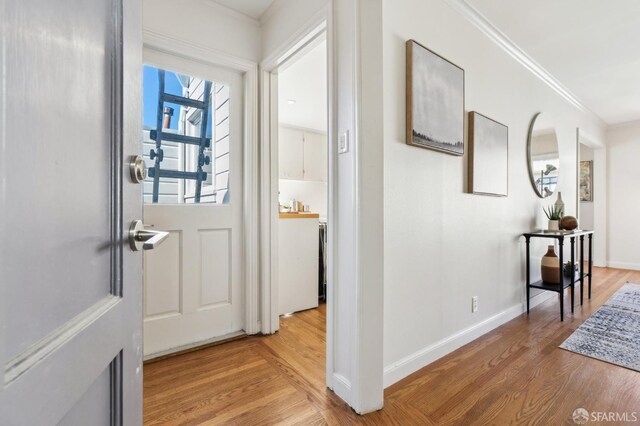 interior space featuring baseboards, wood finished floors, and crown molding