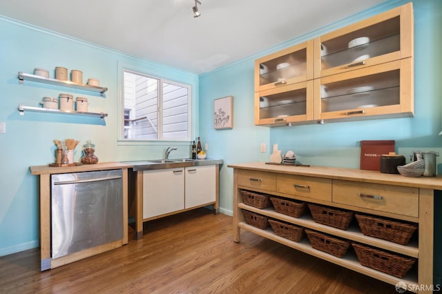 bar featuring dishwasher, light wood finished floors, a sink, and baseboards