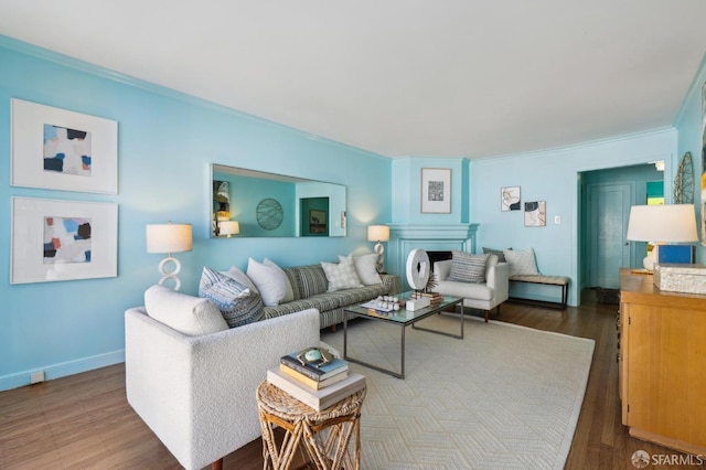 living room with crown molding, baseboards, and wood finished floors