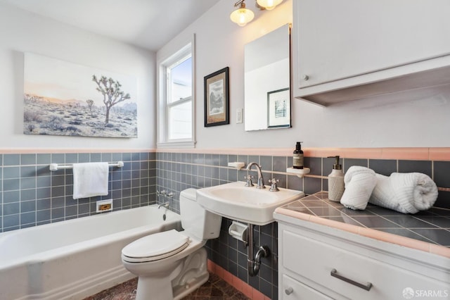 bathroom featuring wainscoting, tile walls, toilet, and a bath