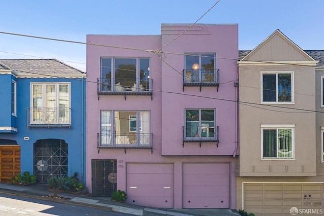 multi unit property with a garage and stucco siding