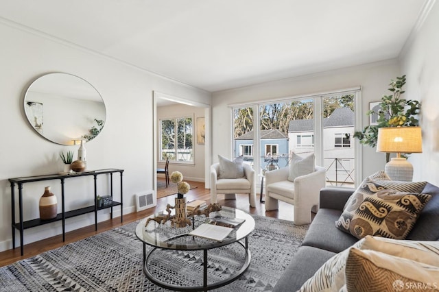 living area featuring visible vents, baseboards, and wood finished floors