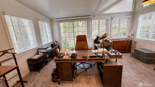 carpeted home office featuring vaulted ceiling and a healthy amount of sunlight