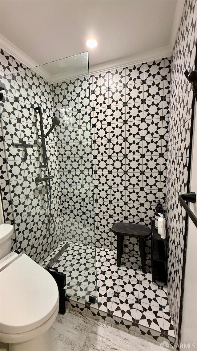 full bath with crown molding, toilet, and a shower stall