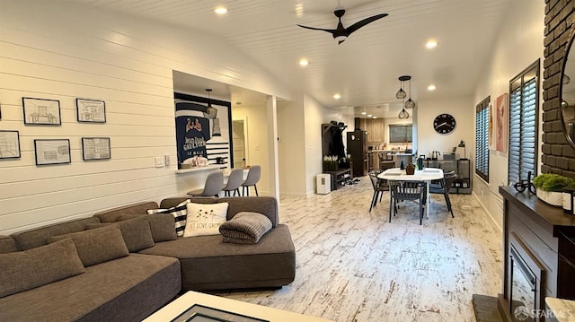 living room with light wood-type flooring, ceiling fan, vaulted ceiling, and recessed lighting