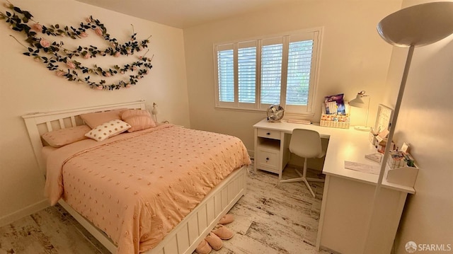 bedroom with light wood-style flooring and baseboards