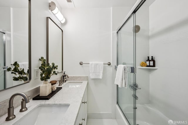 bathroom with vanity and bath / shower combo with glass door