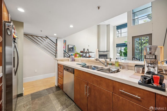 700 Illinois St Unit 3, San Francisco, CA 94107 - kitchen featuring stainless steel appliances, light countertops, a glass covered fireplace, recessed lighting, and brown cabinets