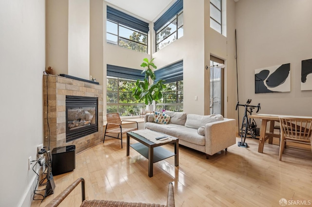 700 Illinois St Unit 3, San Francisco, CA 94107 - living room featuring a towering ceiling, healthy amount of natural light, a glass covered fireplace, and hardwood / wood-style flooring
