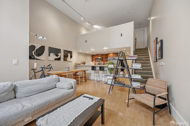 700 Illinois St Unit 3, San Francisco, CA 94107 - living area featuring light wood-style flooring, rail lighting, a high ceiling, and stairway