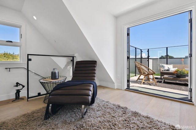 sitting room featuring baseboards, wood finished floors, and vaulted ceiling