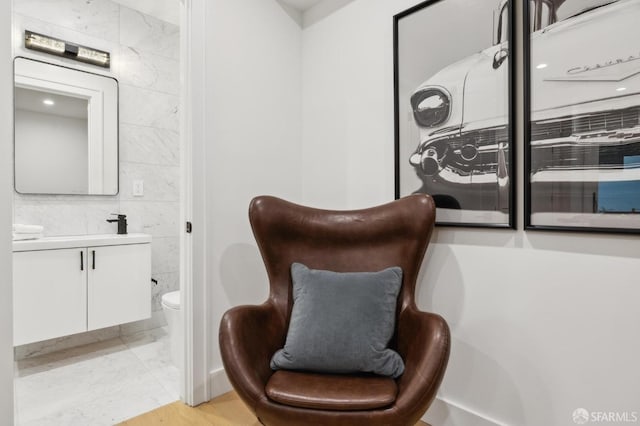 living area with marble finish floor and tile walls