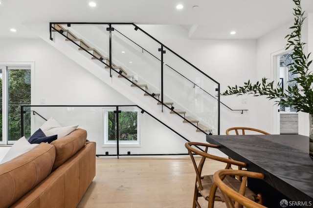 dining space featuring light wood finished floors, recessed lighting, and stairs