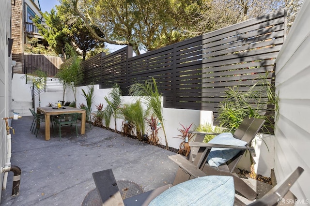 view of patio with outdoor dining space and fence