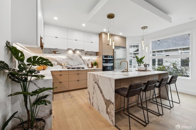 kitchen with decorative backsplash, modern cabinets, and light wood-type flooring