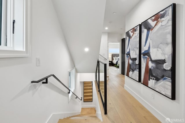 stairs with recessed lighting, wood finished floors, baseboards, and a healthy amount of sunlight