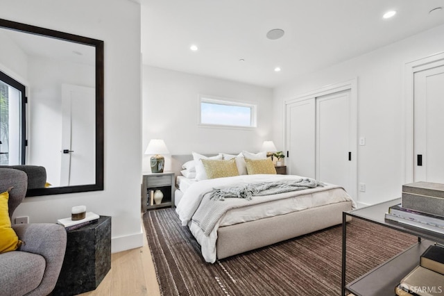 bedroom with recessed lighting, light wood-style floors, and baseboards