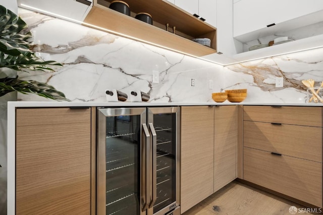 kitchen with beverage cooler, open shelves, light countertops, light wood-style floors, and tasteful backsplash