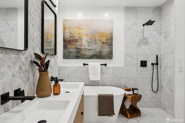 full bathroom with tiled shower, double vanity, a sink, a freestanding bath, and tile walls