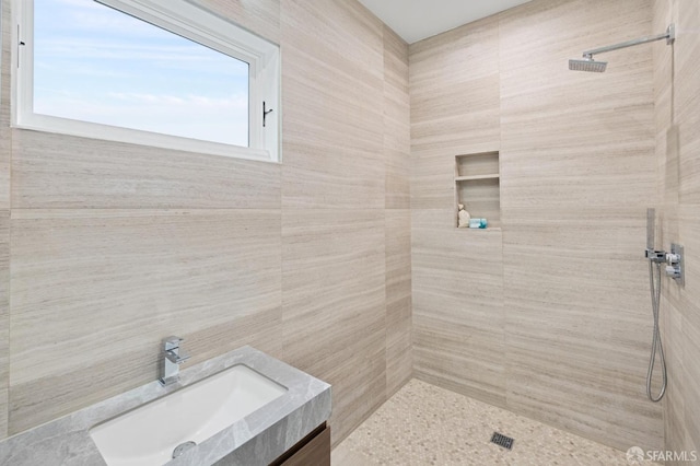 bathroom with tiled shower and vanity