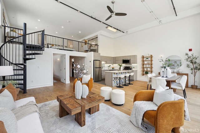 2011 3rd St Unit 6, San Francisco, CA 94107 - living area with a high ceiling, a ceiling fan, light wood finished floors, stairs, and baseboards