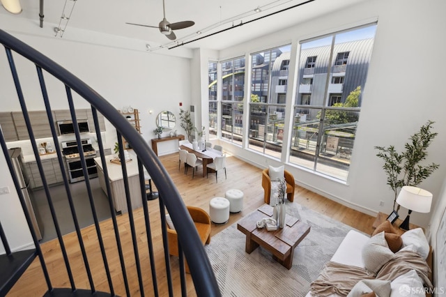 2011 3rd St Unit 6, San Francisco, CA 94107 - living area featuring light wood-style flooring, stairway, a ceiling fan, and baseboards