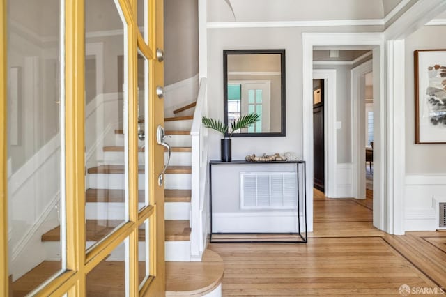 interior space with crown molding and light hardwood / wood-style floors