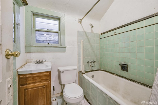 full bathroom featuring tiled shower / bath combo, vanity, toilet, and lofted ceiling