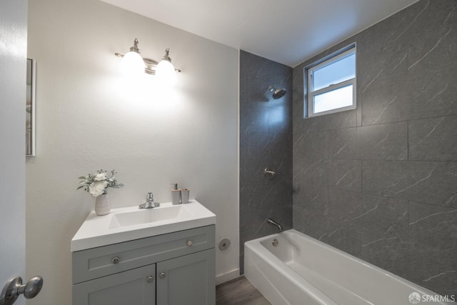 bathroom with vanity, tiled shower / bath combo, and wood-type flooring