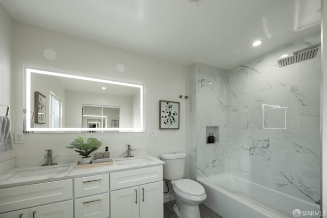 full bathroom featuring vanity, tiled shower / bath combo, and toilet