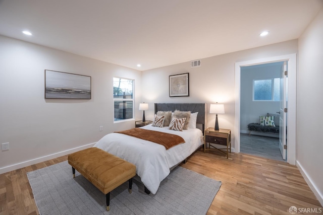 bedroom featuring light hardwood / wood-style floors and ensuite bathroom