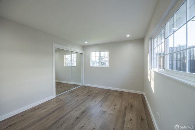 unfurnished bedroom with a closet and light hardwood / wood-style floors