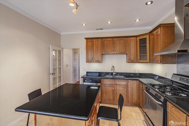 kitchen featuring wall chimney exhaust hood, gas range, sink, a breakfast bar area, and light tile patterned flooring